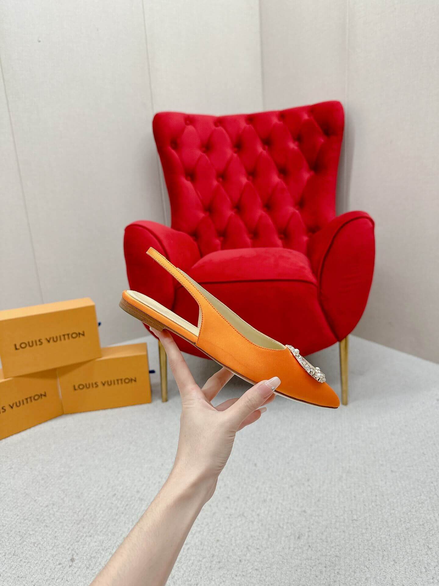 a pair of Louis Vuitton Inspired Crystal Slingback – Orange Luxe Edition on a marble table