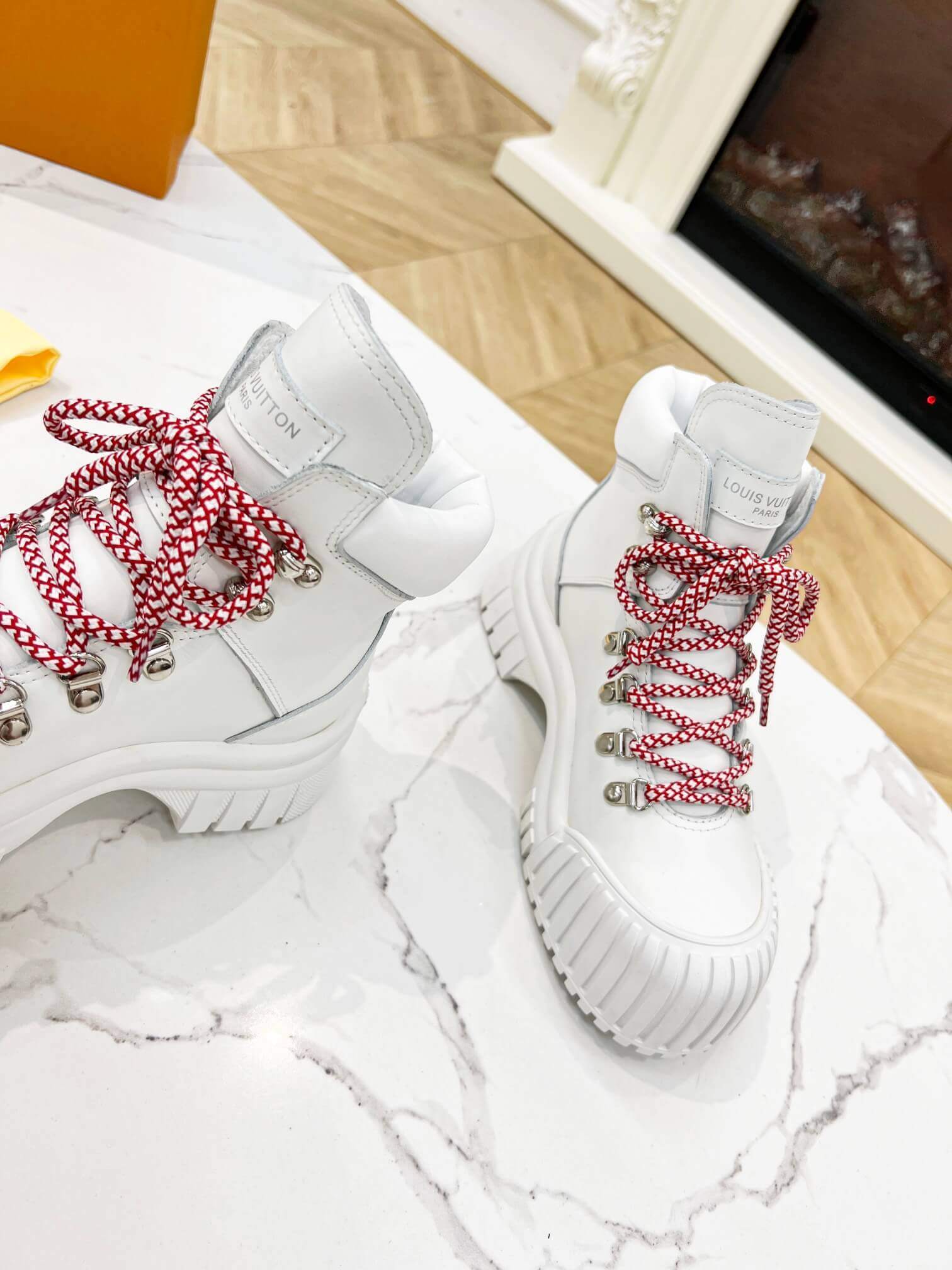 a pair of Louis Vuitton LV Ranger Boot In White Leather with Red Laces