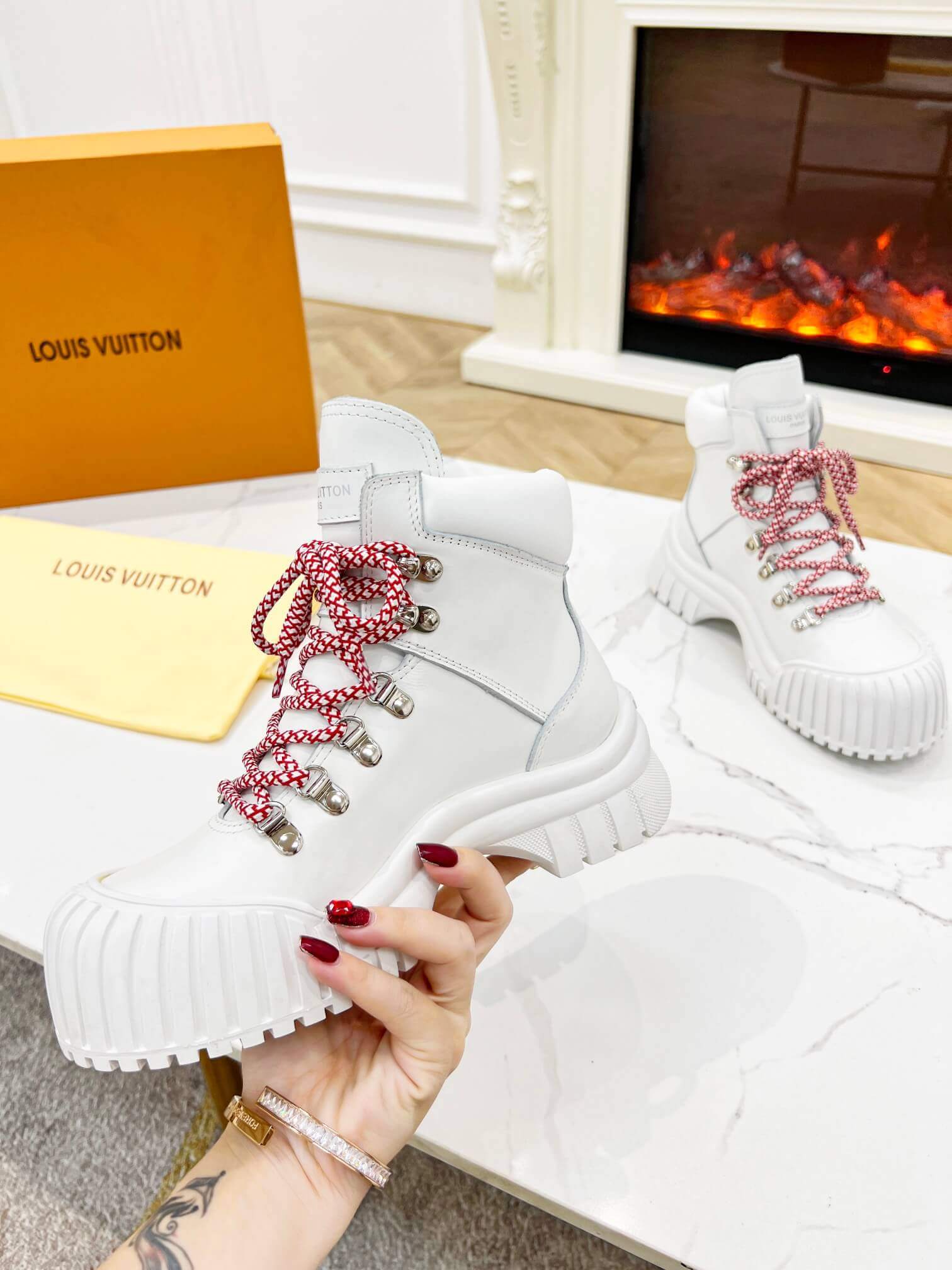 a pair of Louis Vuitton LV Ranger Boot In White Leather with Red Laces
