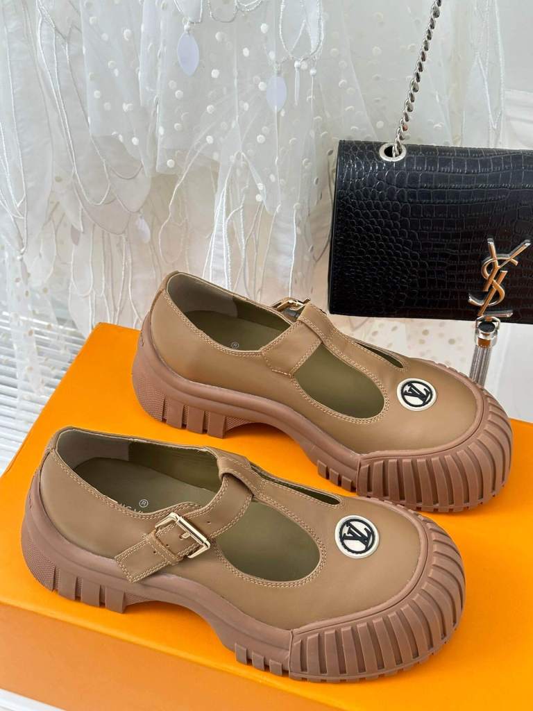 a pair of Louis Vuitton LV Ruby Flat Mary Jane in beige. on a yellow box