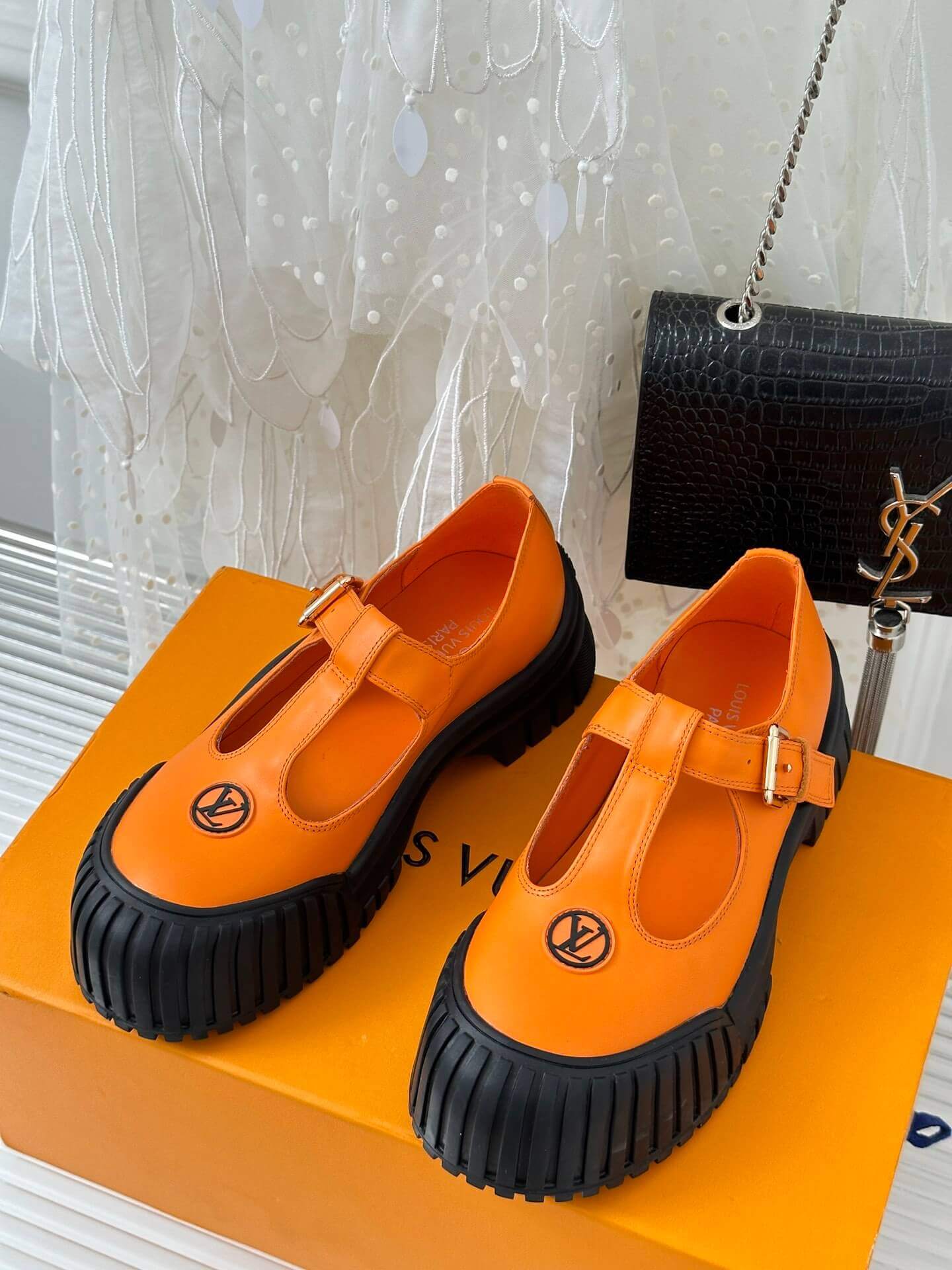 a pair of Louis Vuitton LV Ruby Flat Mary Jane in orange and black