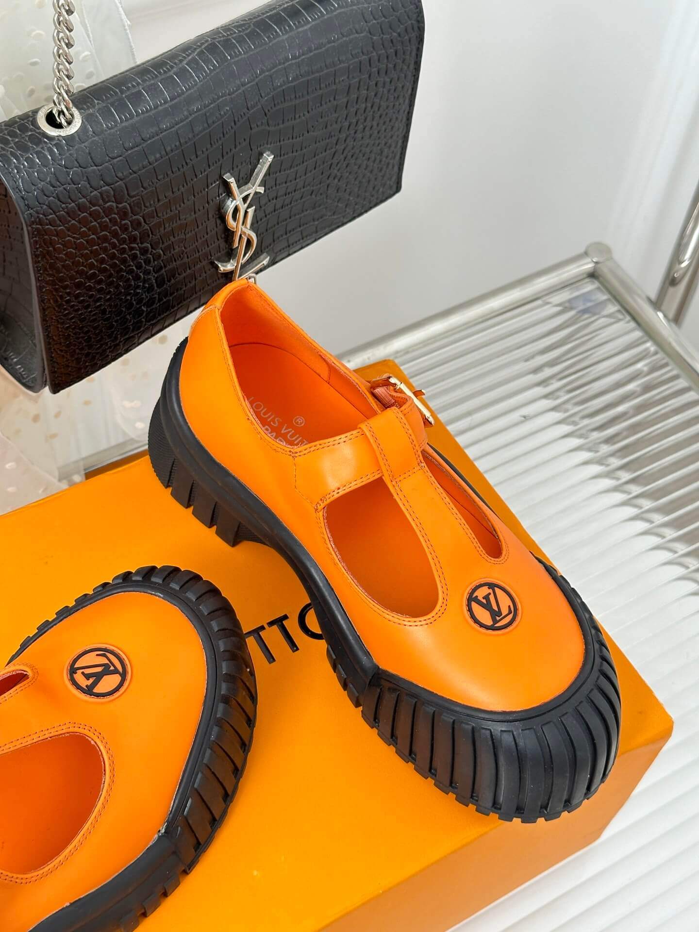 a pair of Louis Vuitton LV Ruby Flat Mary Jane in orange and black