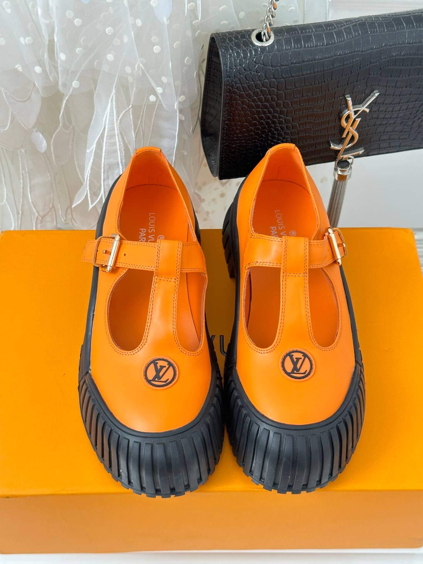 a pair of Louis Vuitton LV Ruby Flat Mary Jane in orange and black