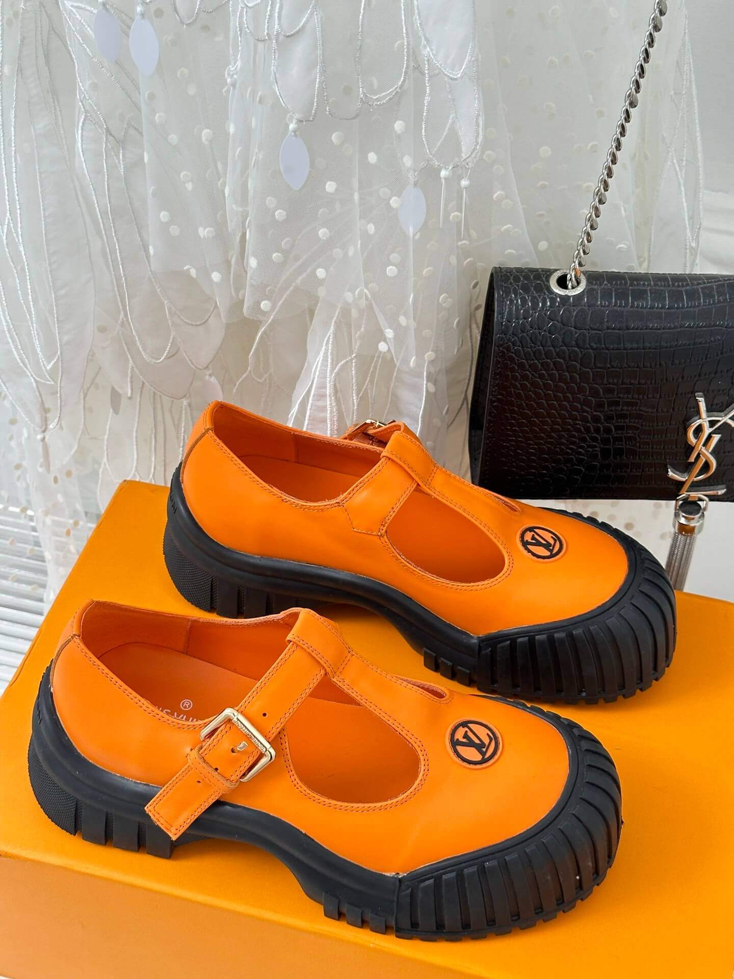 a pair of Louis Vuitton LV Ruby Flat Mary Jane in orange and black