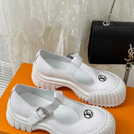 a pair of Louis Vuitton LV Ruby Flat Mary Jane in white with black accents on an orange box