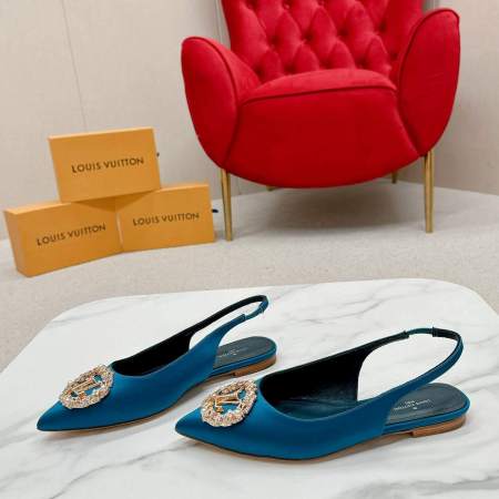 a pair ofLouis Vuitton Madeleine Crystal Slingback –In Teal Blue on a marble table