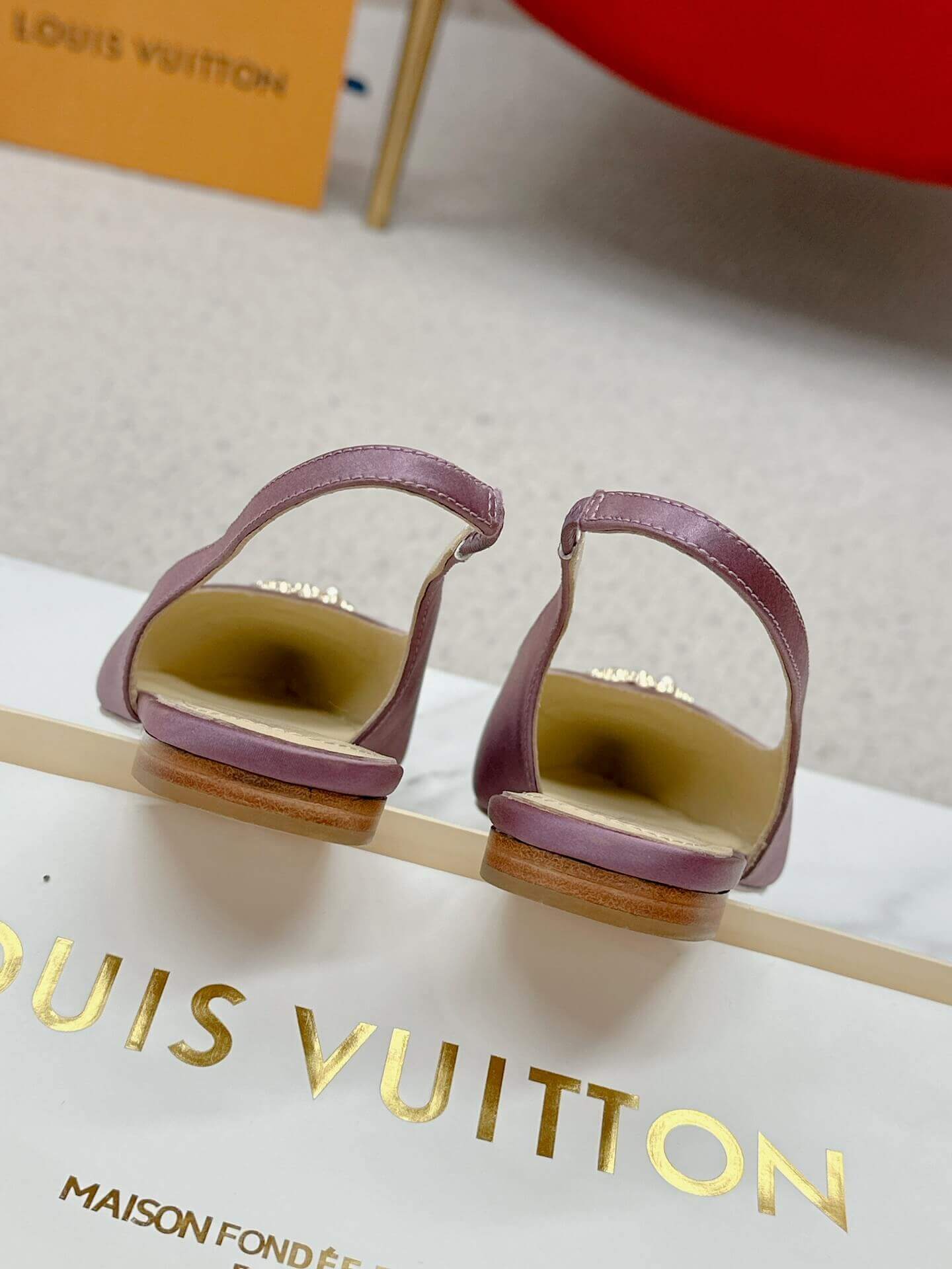 a pair of Louis Vuitton Purple Slingback Flat on a box