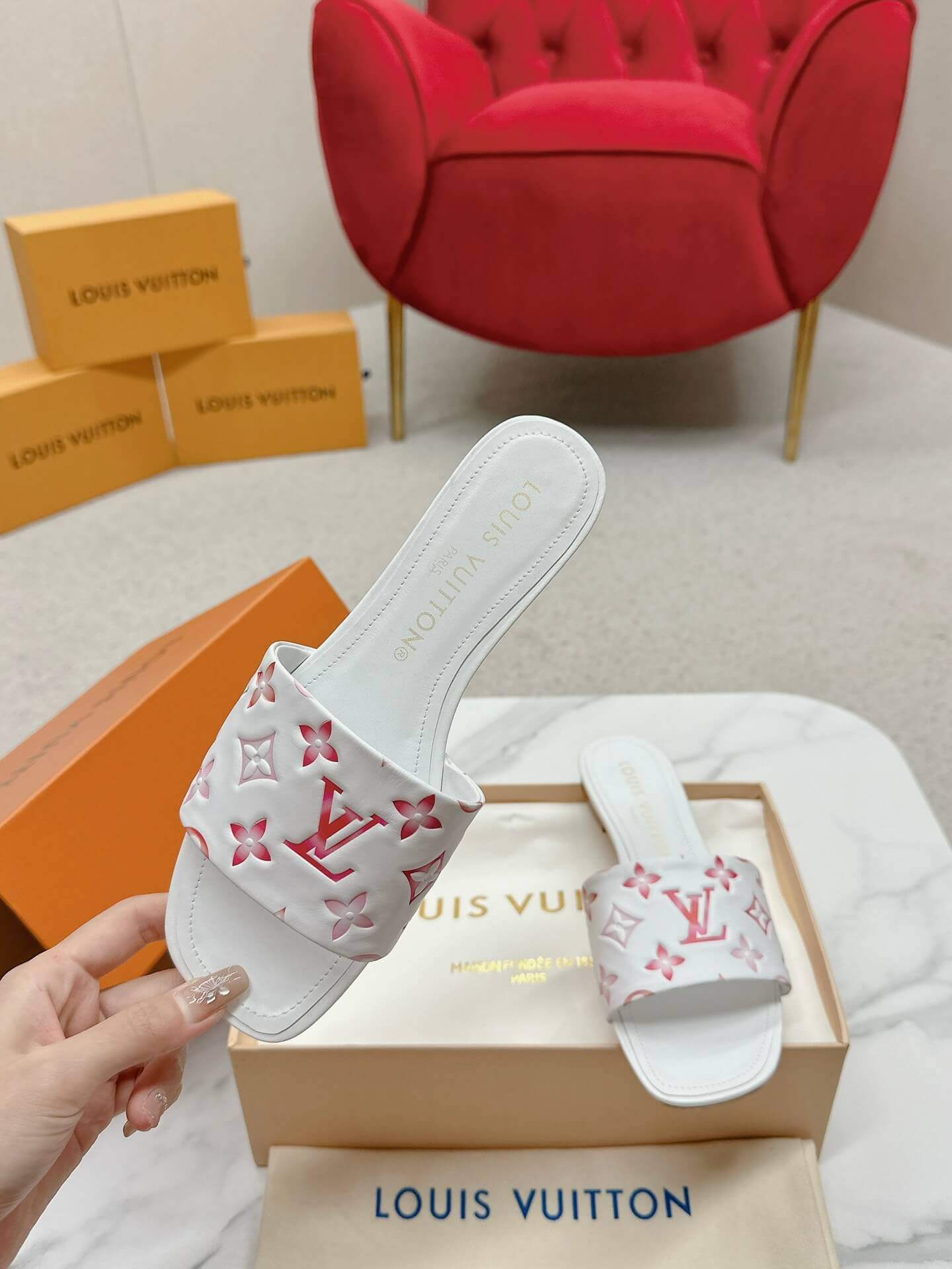 a pair of Louis Vuitton White Monogram Slide Sandals – Pink Edition on a marble surface