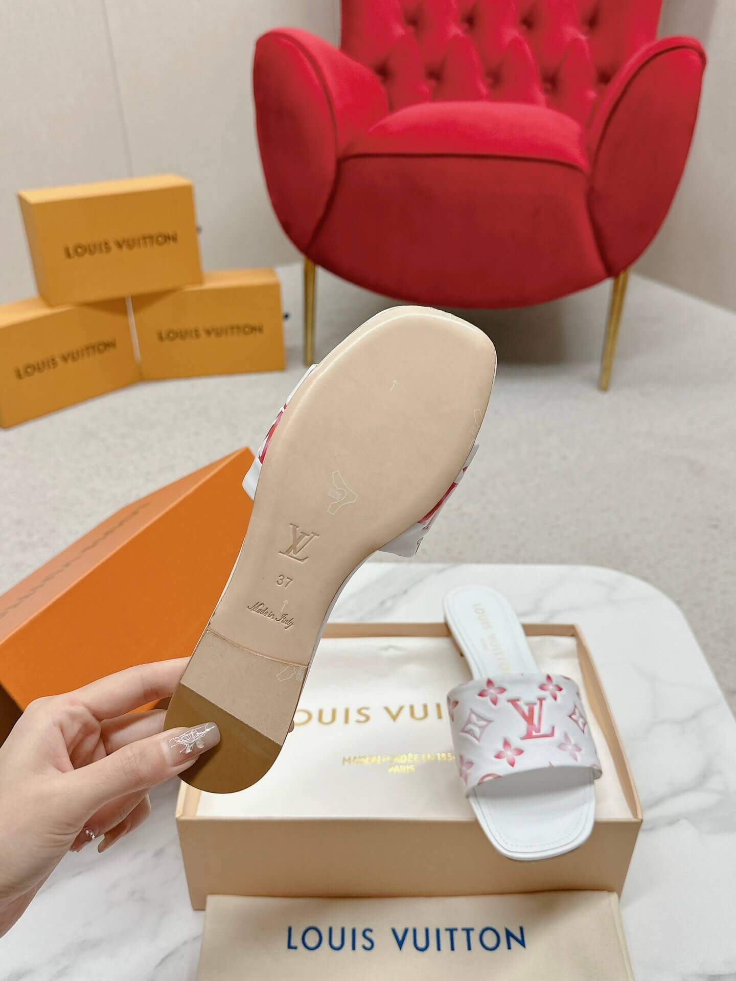 a pair of Louis Vuitton White Monogram Slide Sandals – Pink Edition on a marble surface