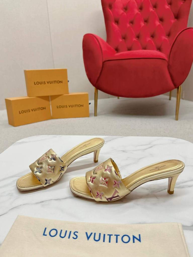 a pair of Louis Vuitton Revival Mule in Gold Monogram-Embossed Lambskin Heel on a marble surface