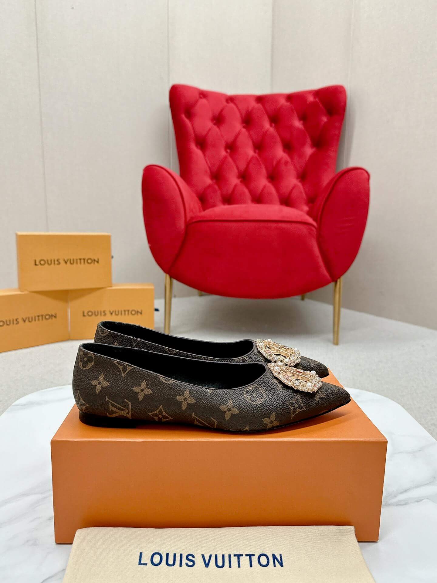 a pair of Louis Vuitton Revival Mule in Monogram Canvas – Crystal‑Embellished Flat Shoe on a box
