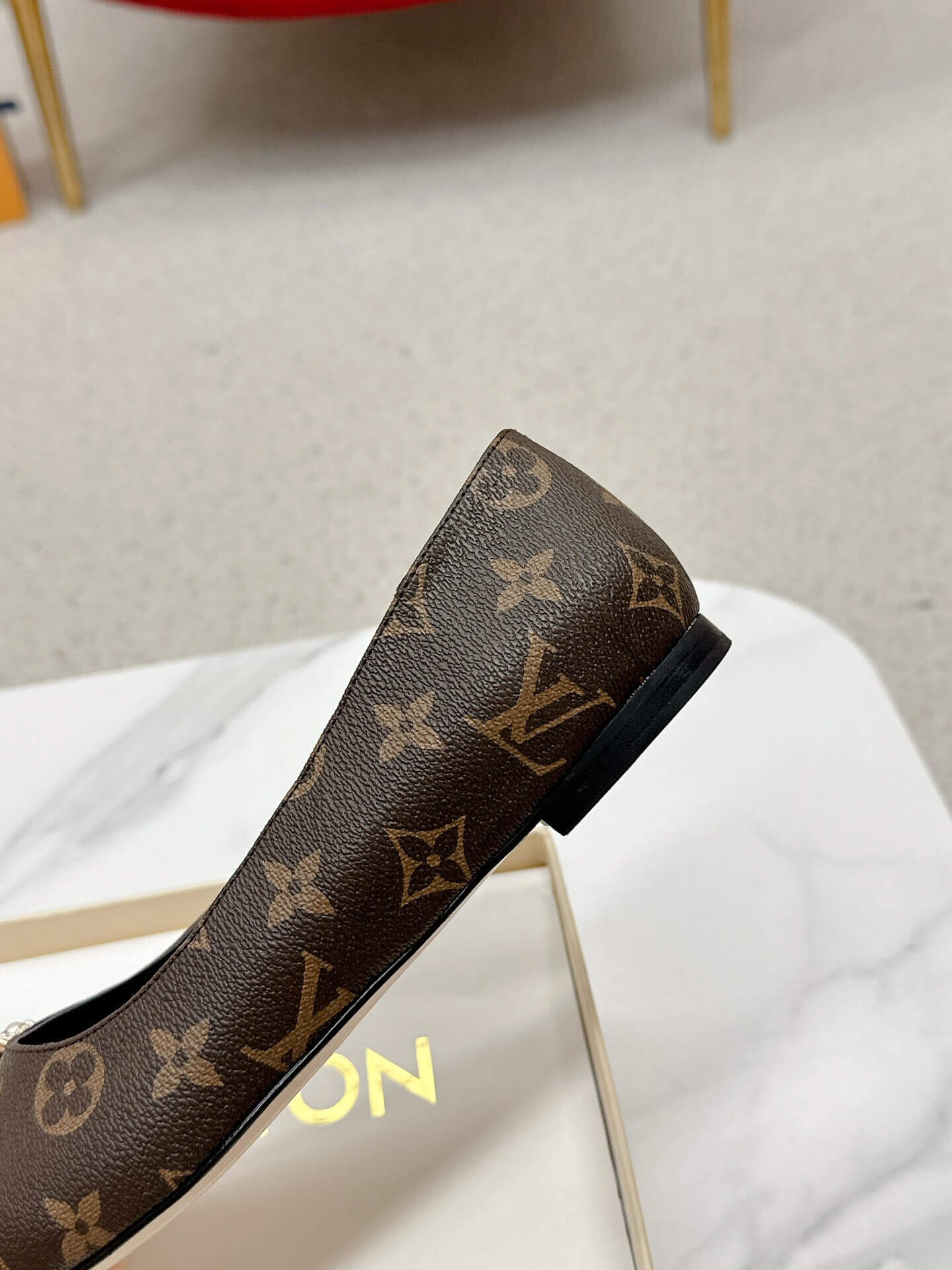 a pair of Louis Vuitton Revival Mule in Monogram Canvas – Crystal‑Embellished Flat Shoe on a box