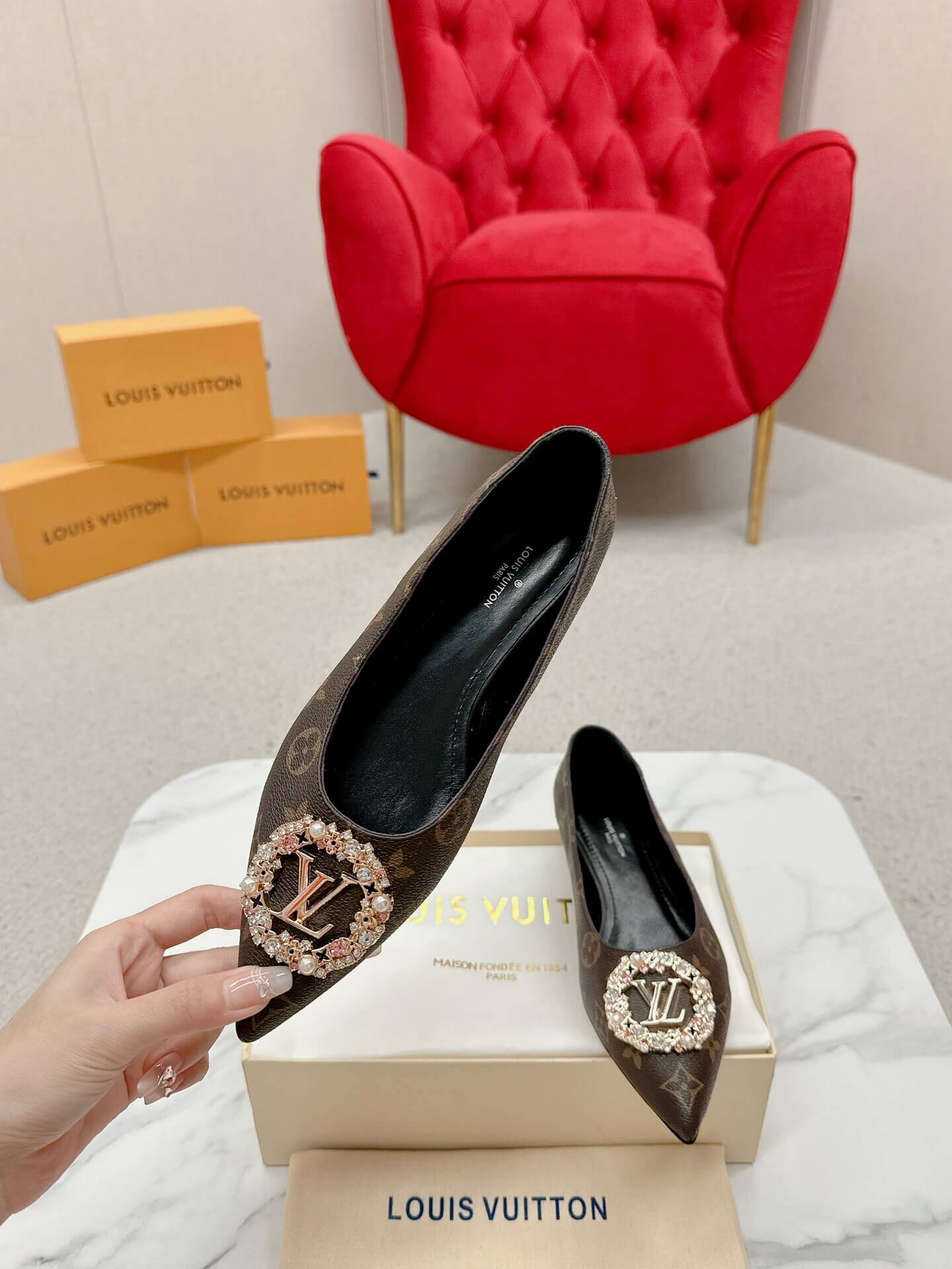 a pair of Louis Vuitton Revival Mule in Monogram Canvas – Crystal‑Embellished Flat Shoe on a box