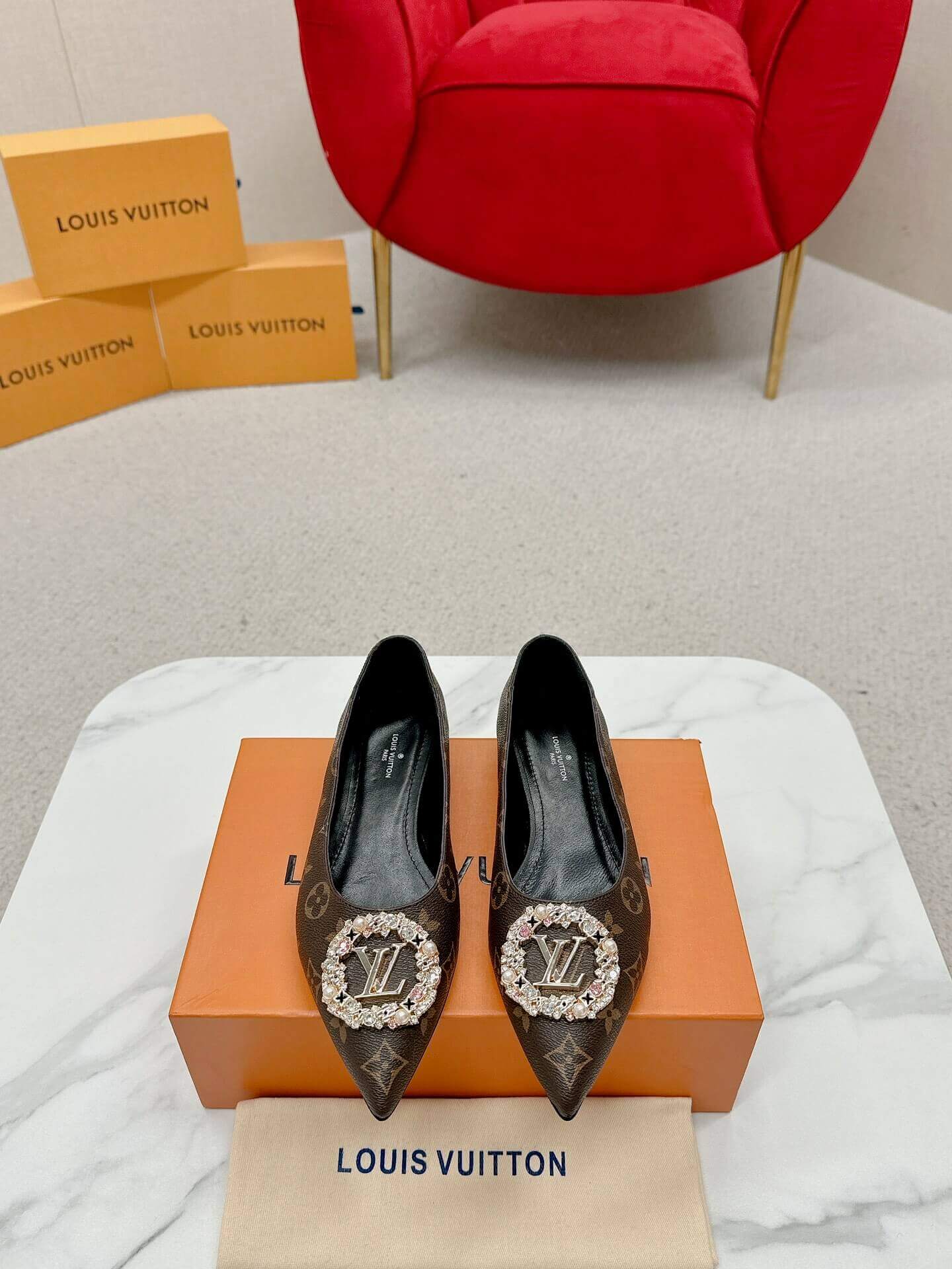 a pair of Louis Vuitton Revival Mule in Monogram Canvas – Crystal‑Embellished Flat Shoe on a box