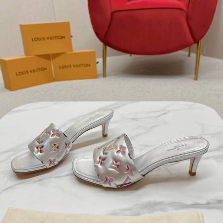 a pair of Louis Vuitton Revival Mule in Silver Metallic Monogram‑Embossed Heel on a marble surface
