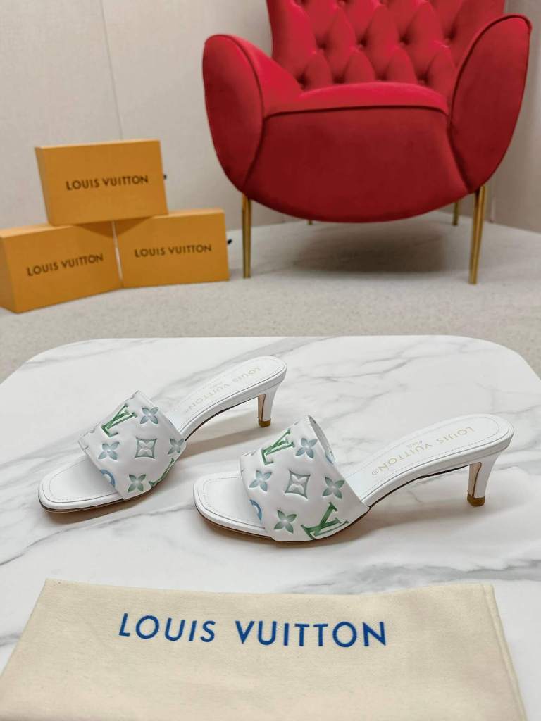 a pair of Louis Vuitton Revival Mule in White and Green Monogram-Embossed Lambskin Heel on a marble surface