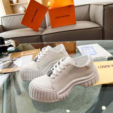a pair of Louis Vuitton Ruby Flat Derby Shoe In white on a glass table