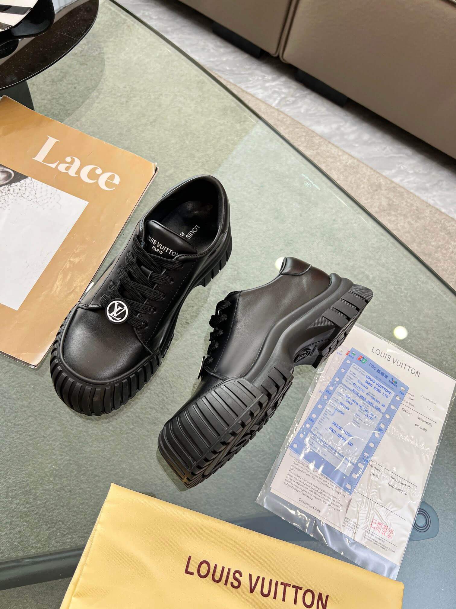 a pair of Louis Vuitton Ruby Flat Derby Shoe in black on a glass table