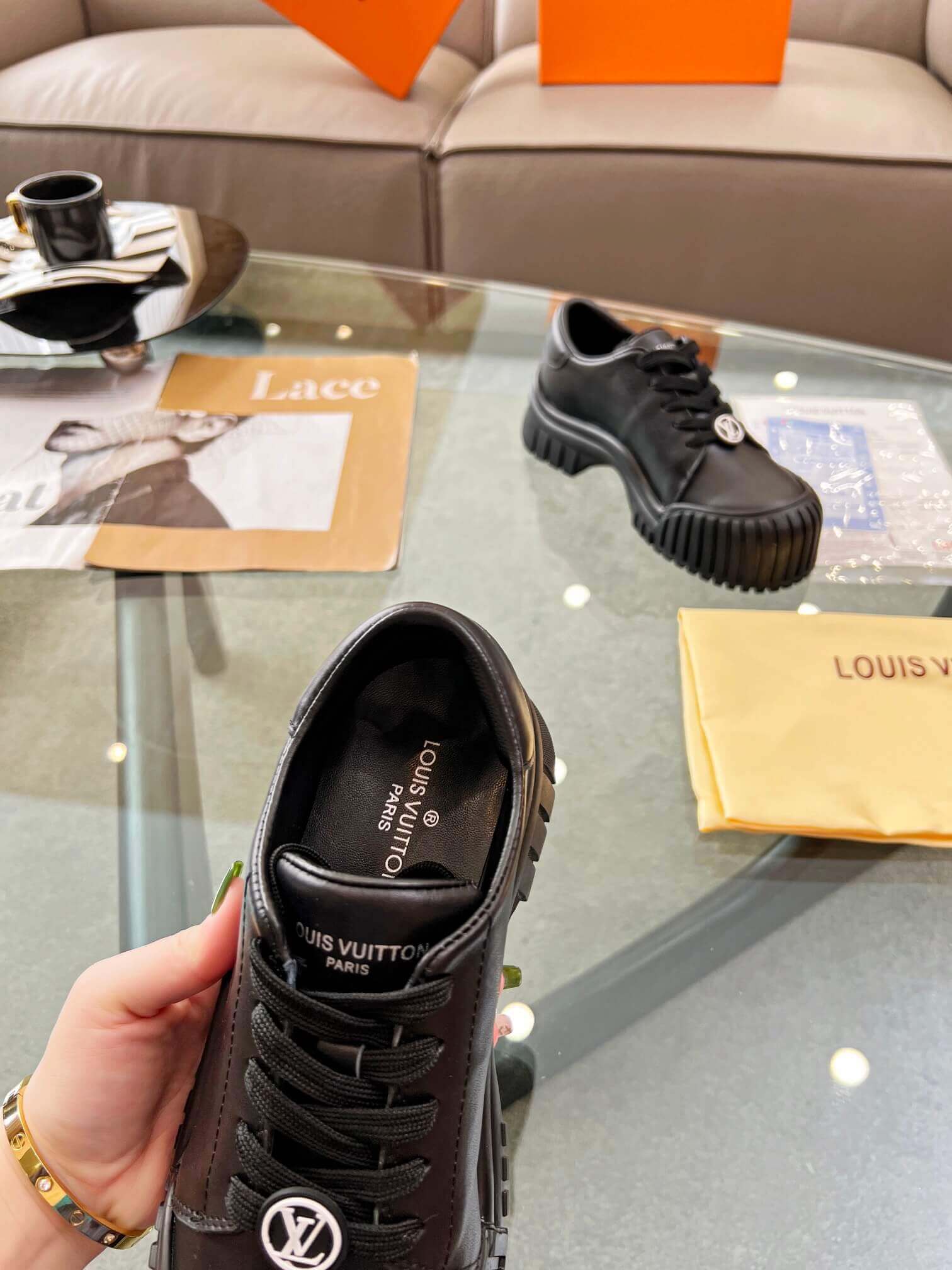a pair of Louis Vuitton Ruby Flat Derby Shoe in black on a glass table