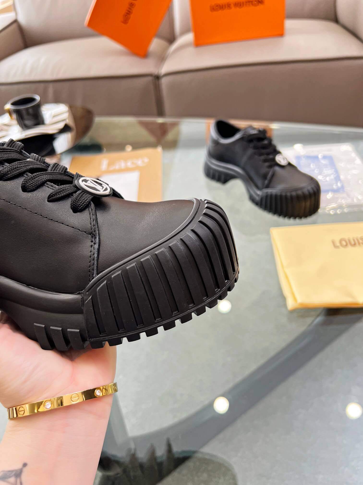 a pair of Louis Vuitton Ruby Flat Derby Shoe in black on a glass table