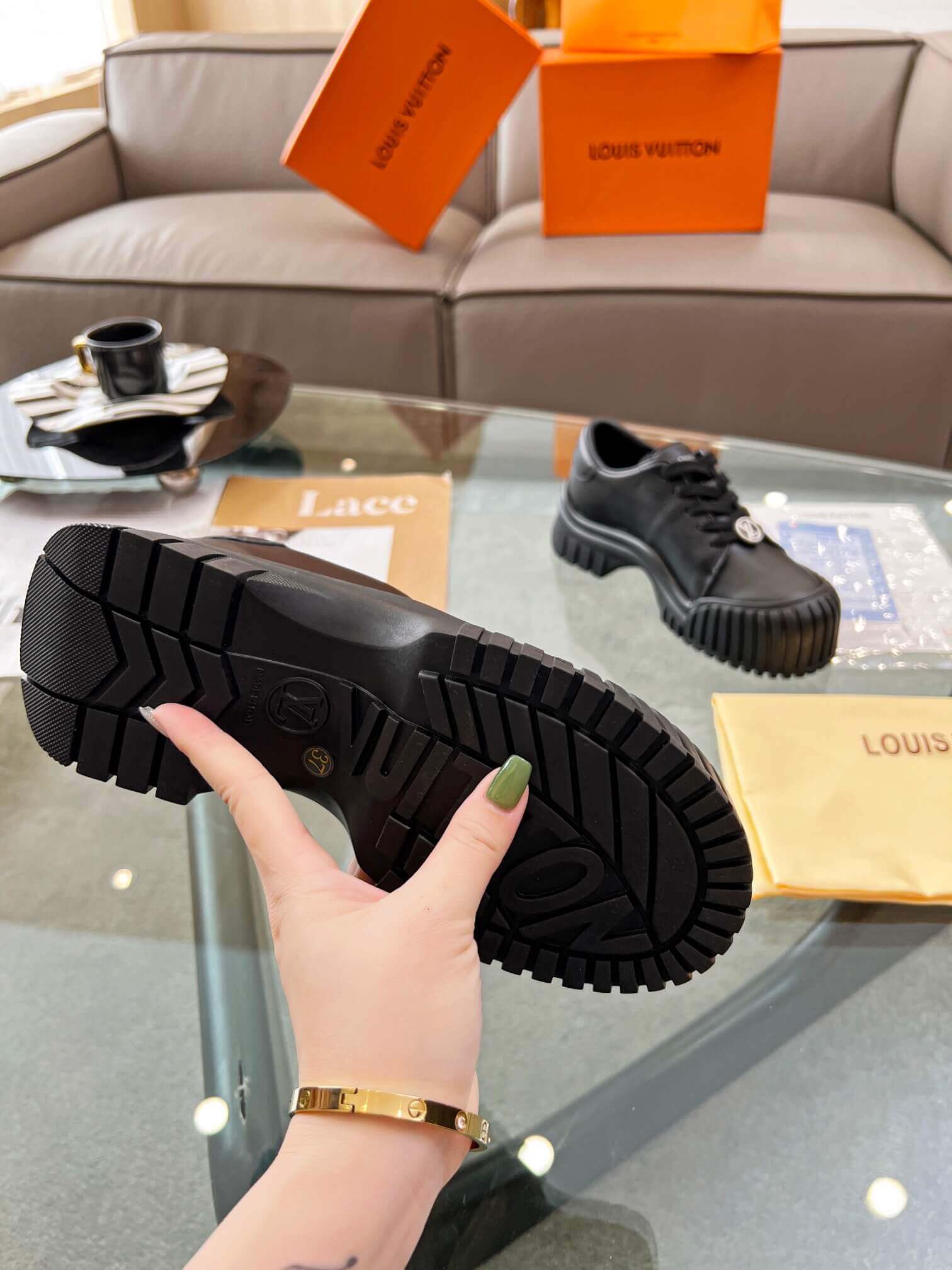 a pair of Louis Vuitton Ruby Flat Derby Shoe in black on a glass table