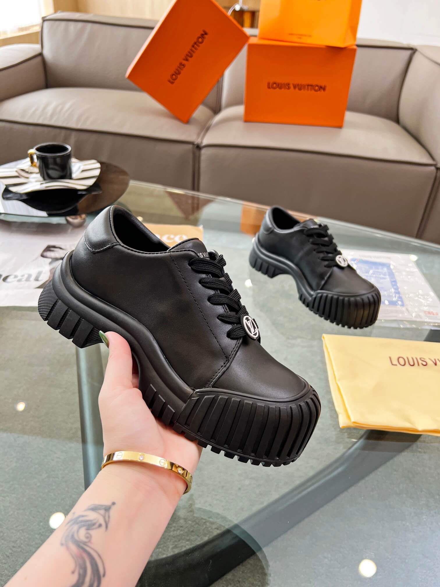 a pair of Louis Vuitton Ruby Flat Derby Shoe in black on a glass table