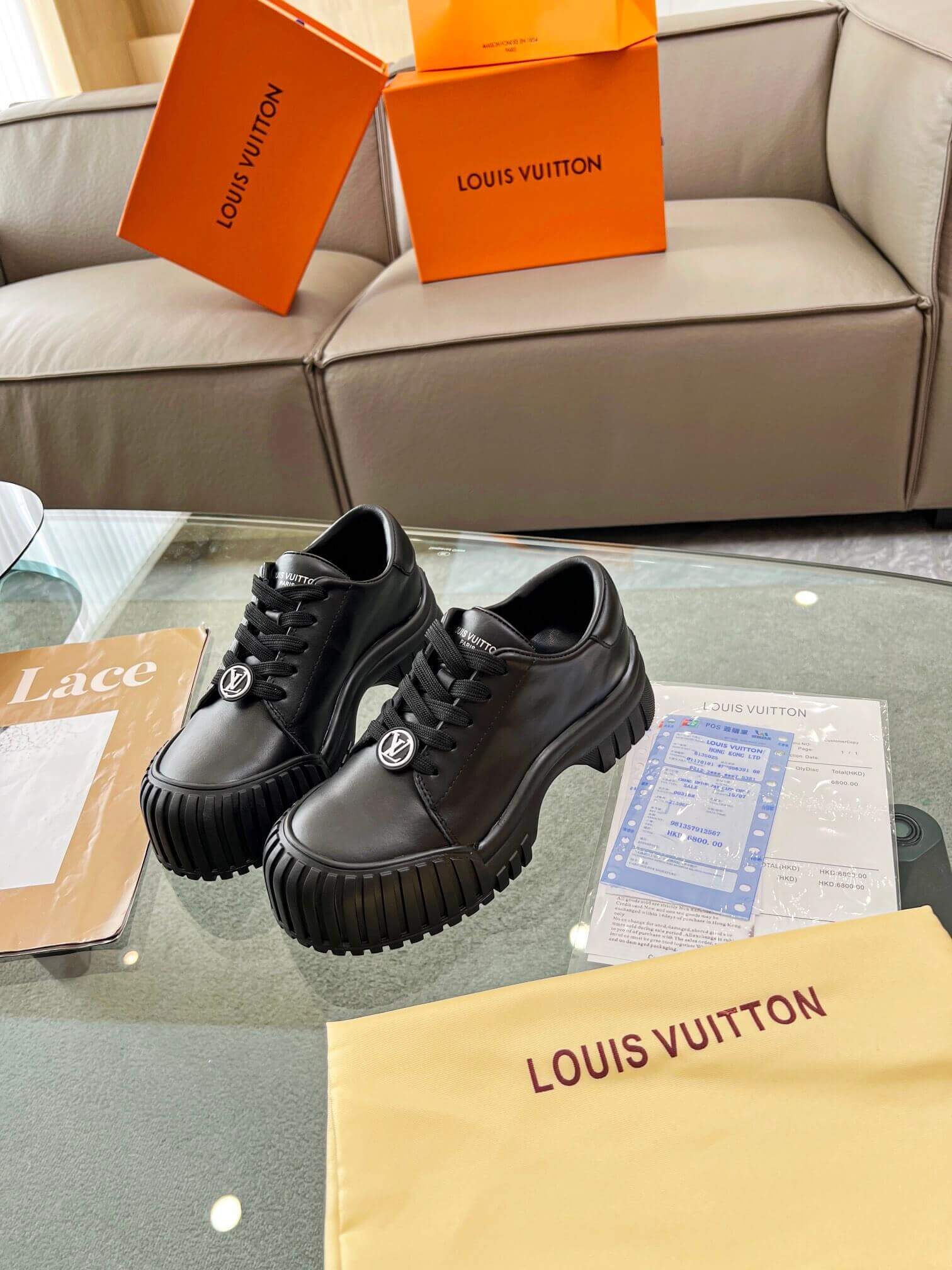 a pair of Louis Vuitton Ruby Flat Derby Shoe in black on a glass table