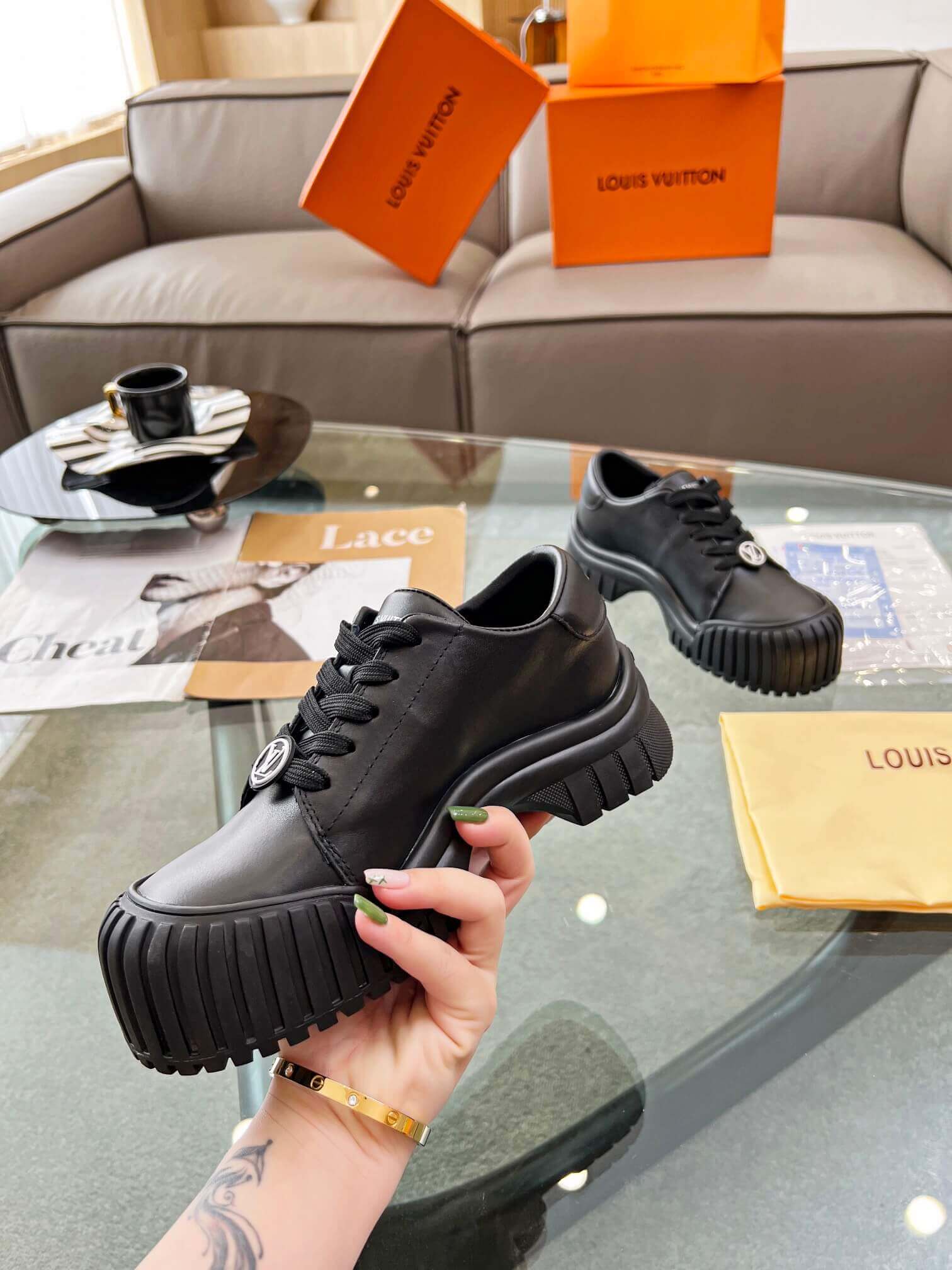 a pair of Louis Vuitton Ruby Flat Derby Shoe in black on a glass table