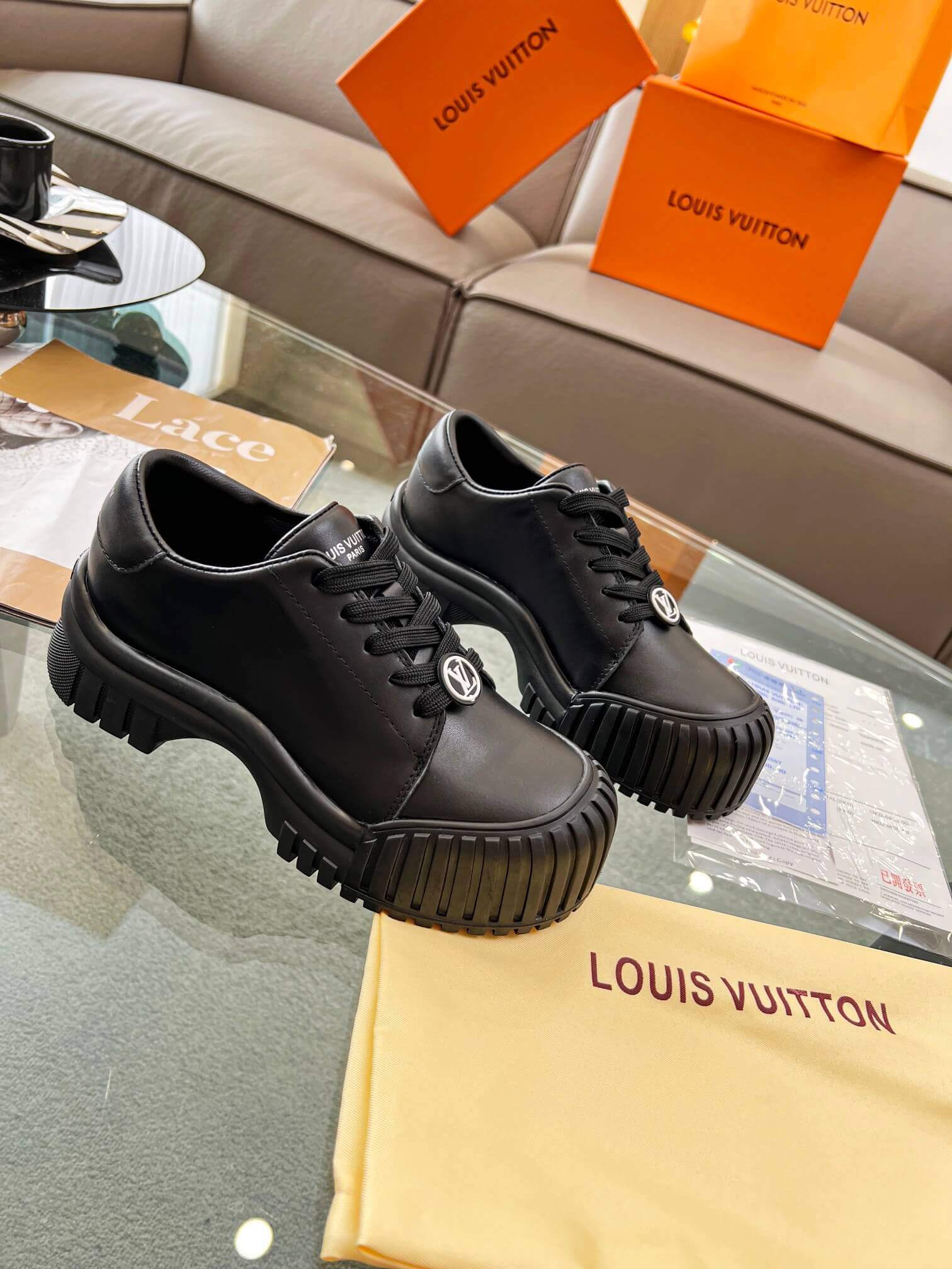 a pair of Louis Vuitton Ruby Flat Derby Shoe in black on a glass table