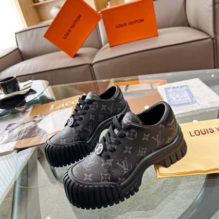 a pair ofLouis Vuitton Ruby Flat Derby Shoe in bold black Monogram canvas on a glass table