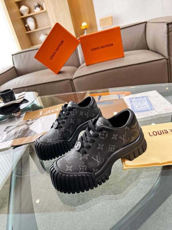 a pair ofLouis Vuitton Ruby Flat Derby Shoe in bold black Monogram canvas on a glass table