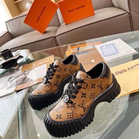 a pair of Louis Vuitton Ruby Flat Derby Shoe in classic brown Monogram canvas on a glass table