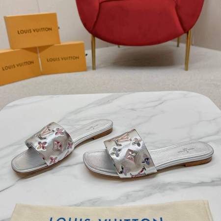 a pair ofLouis Vuitton Silver Revival-Inspired Flat Mules – Monogram Metallic Elegance on a marble table