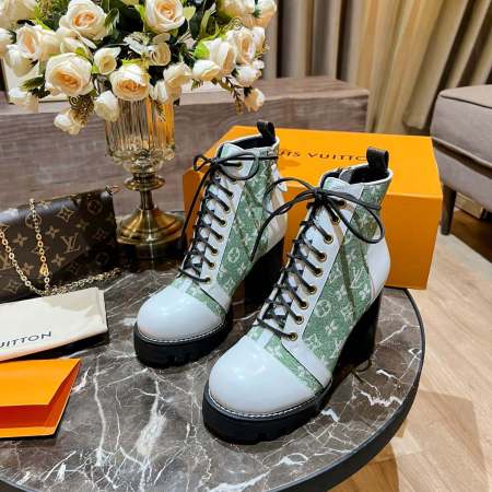 a pair of Louis Vuitton Star Trail Ankle Boots (Green Monogram & White Leather) on a table