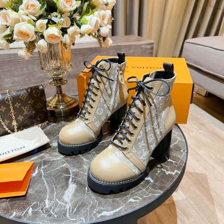 a pair of Louis Vuitton Star Trail Ankle Boots in Beige Monogram Canvas and Beige Leather on a table
