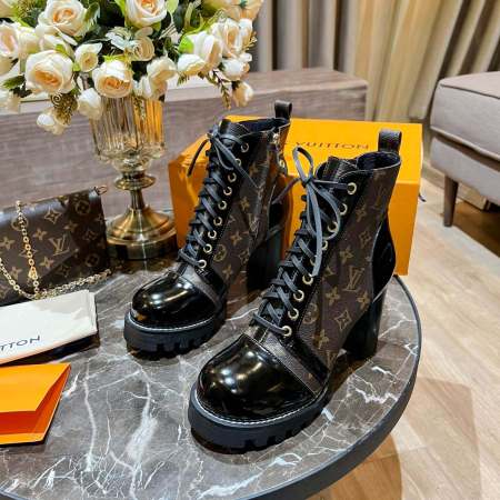 a pair of Louis Vuitton High-Heeled Ankle Boots (Beige & Colorful Monogram) on a marble table