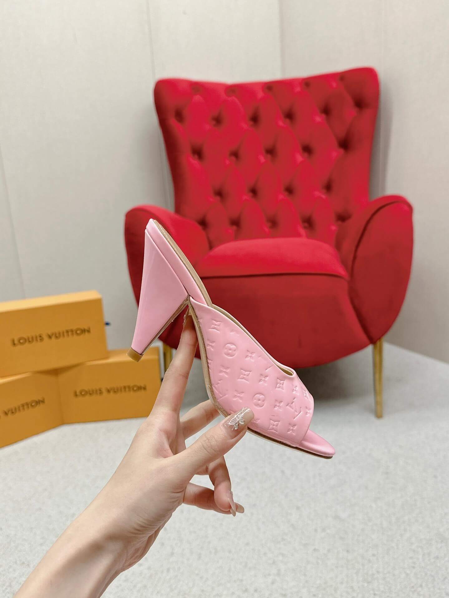 a pair of Louis Vuitton Super Mule – Pink Patent Monogram on a marble surface