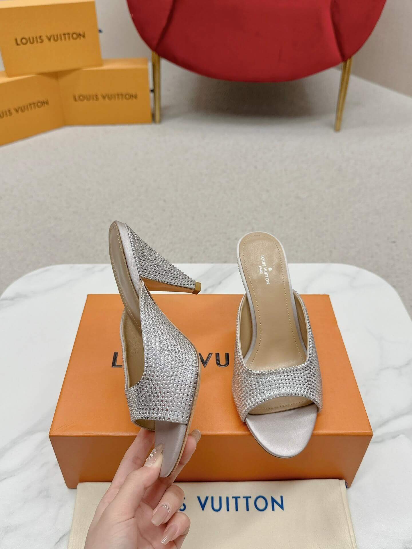 a pair of Louis Vuitton Super Mule – Silver Crystal Elegance on a box