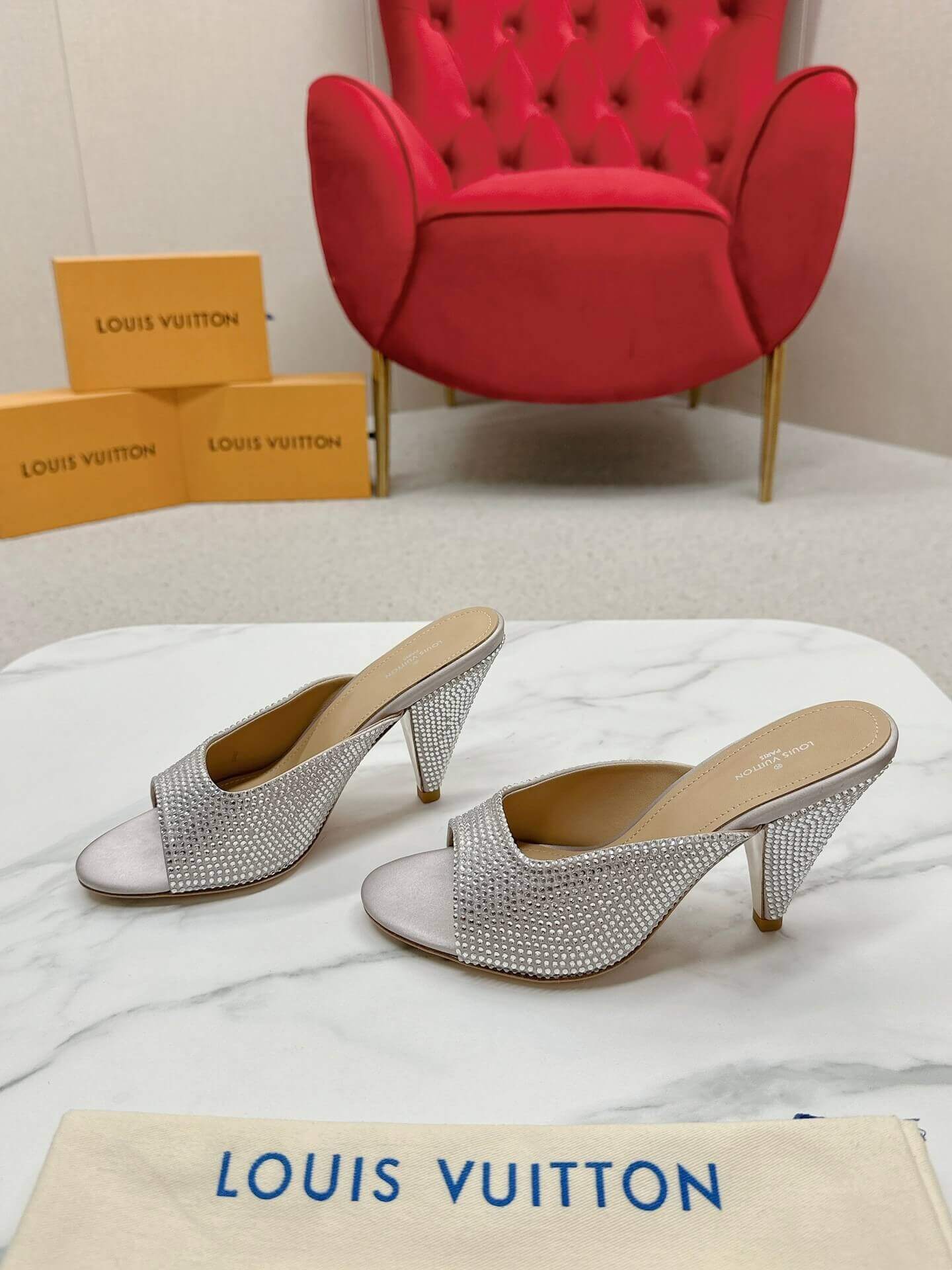 a pair of Louis Vuitton Super Mule – Silver Crystal Elegance on a box