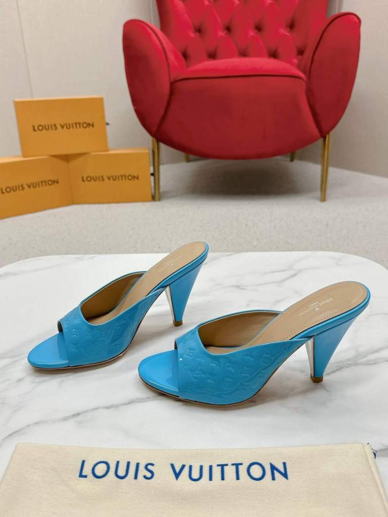 a pair of Louis Vuitton Super Mule in Sky‑Blue Patent on a marble surface