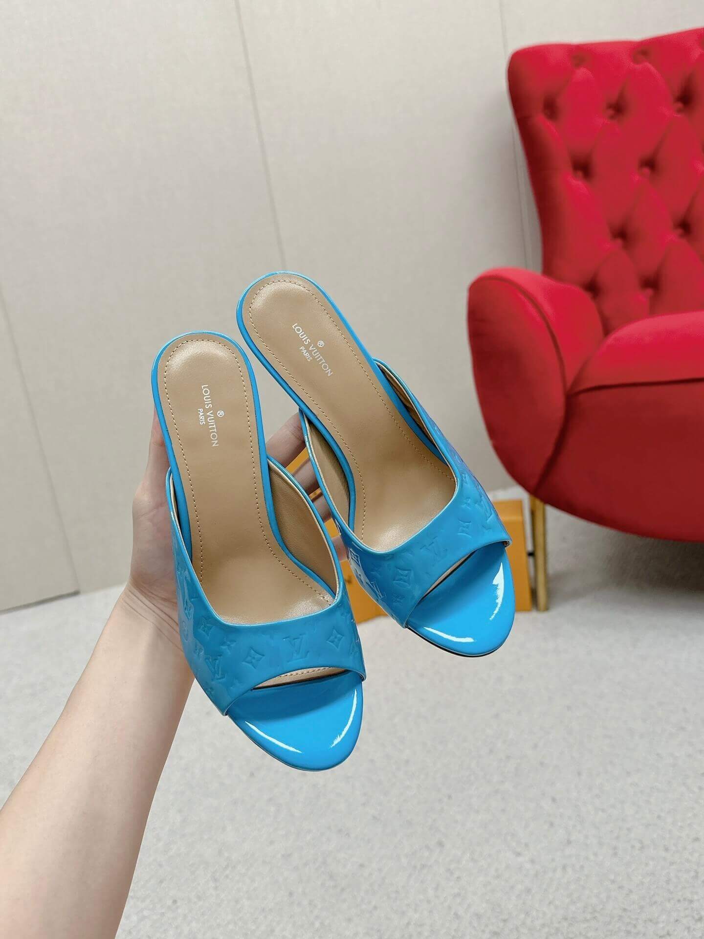 a pair of Louis Vuitton Super Mule in Sky‑Blue Patent on a marble surface