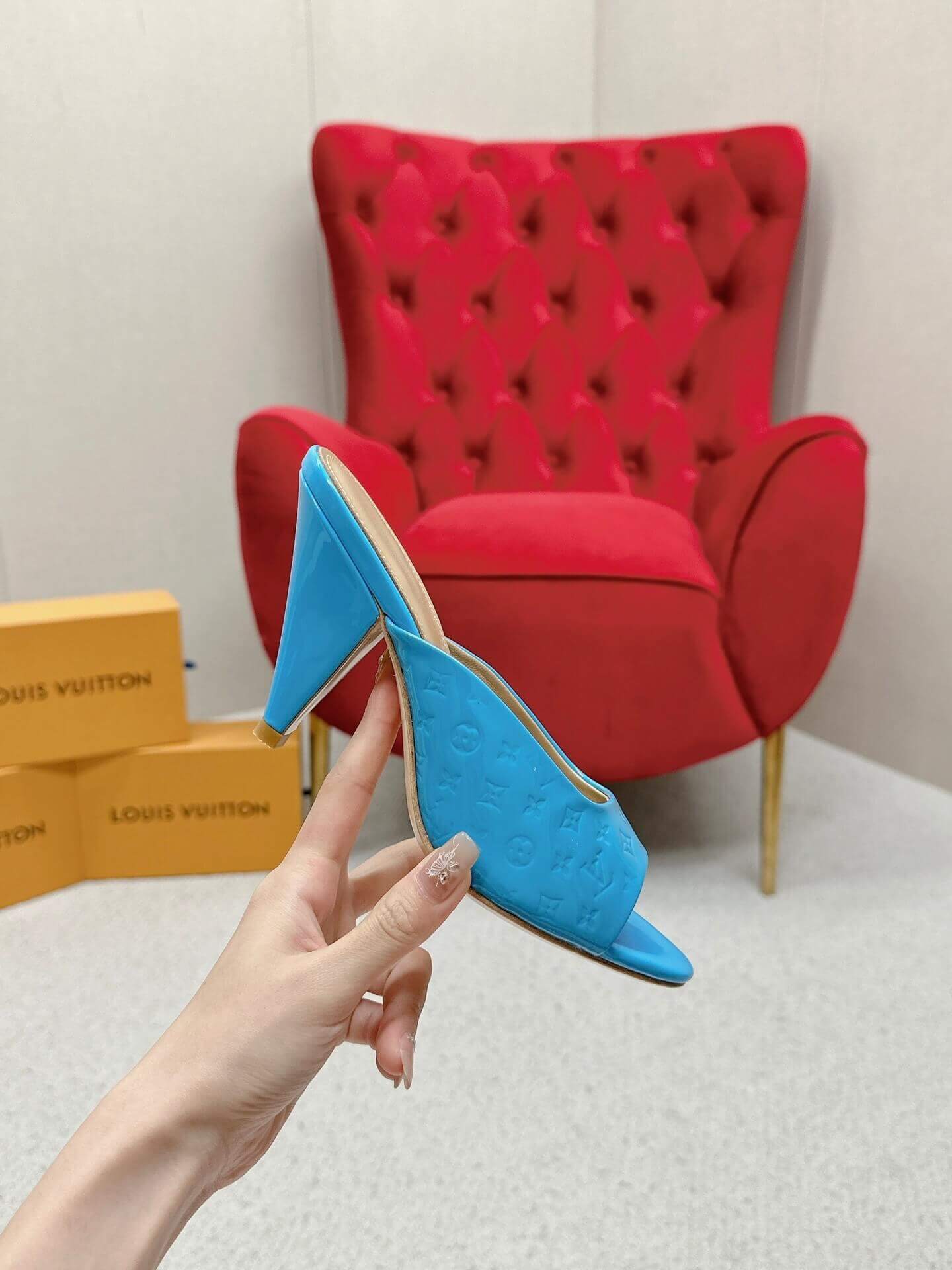 a pair of Louis Vuitton Super Mule in Sky‑Blue Patent on a marble surface
