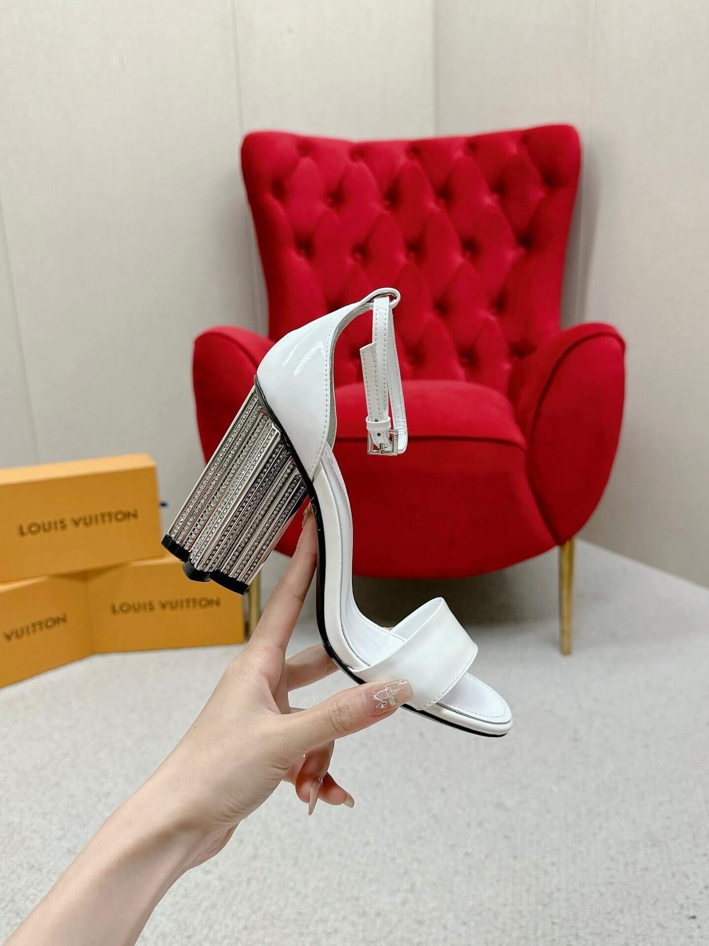 a pair of Louis Vuitton White Patent Leather Silhouette Sandals with Monogram Heel on a box