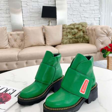 a pair of Louis Vuitton Wonderland Flat Ranger Boots In Bold Green Stride on a table