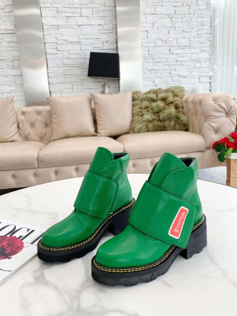 a pair of Louis Vuitton Wonderland Flat Ranger Boots In Bold Green Stride on a table