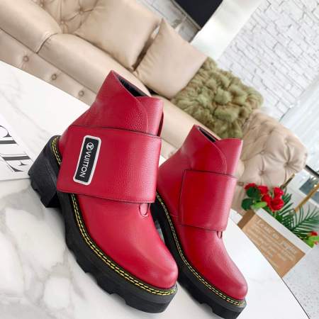 a pair of Louis Vuitton Wonderland Flat Ranger Boots In Red Leather on a table