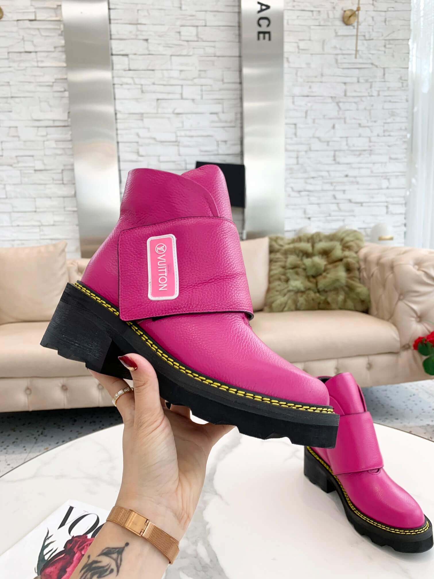 a pair of Louis Vuitton Wonderland Flat Ranger Boots in Pink Leather on a table