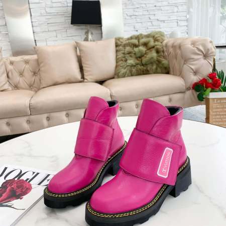 a pair of Louis Vuitton Wonderland Flat Ranger Boots in Pink Leather on a table