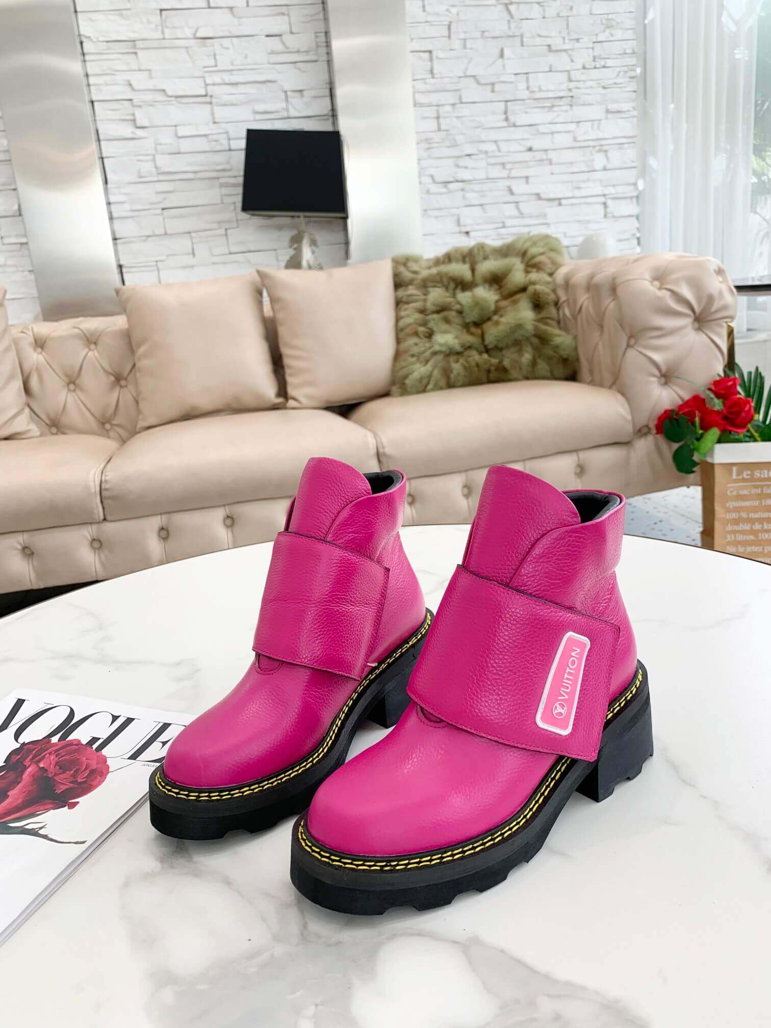 a pair of Louis Vuitton Wonderland Flat Ranger Boots in Pink Leather on a table