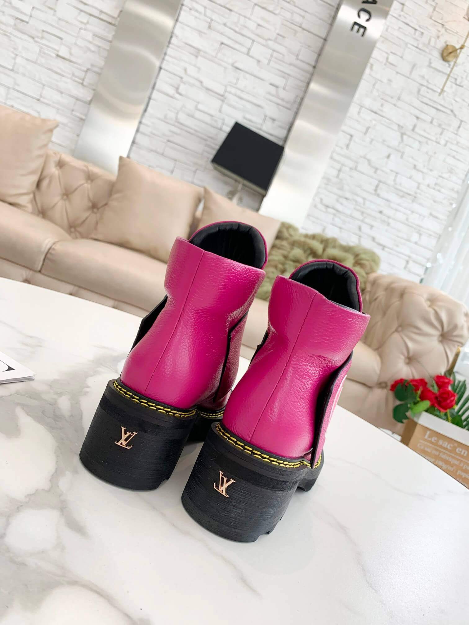 a pair of Louis Vuitton Wonderland Flat Ranger Boots in Pink Leather on a table